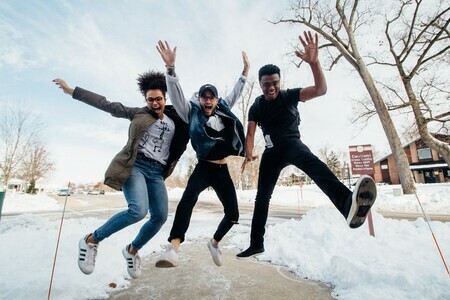 3 students outside jumping 